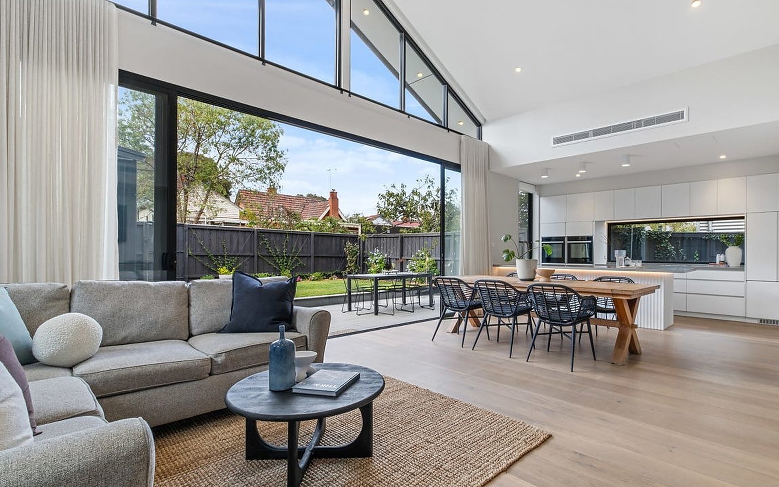 Thornbury extension: open-plan living and dining under a raked ceiling, opening onto the garden