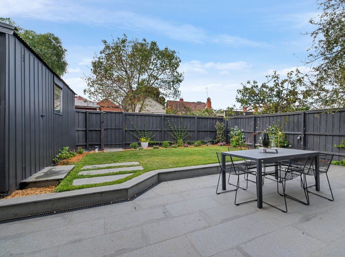 Thornbury outdoor living: bluestone paved terrace and lawn after the rear extension